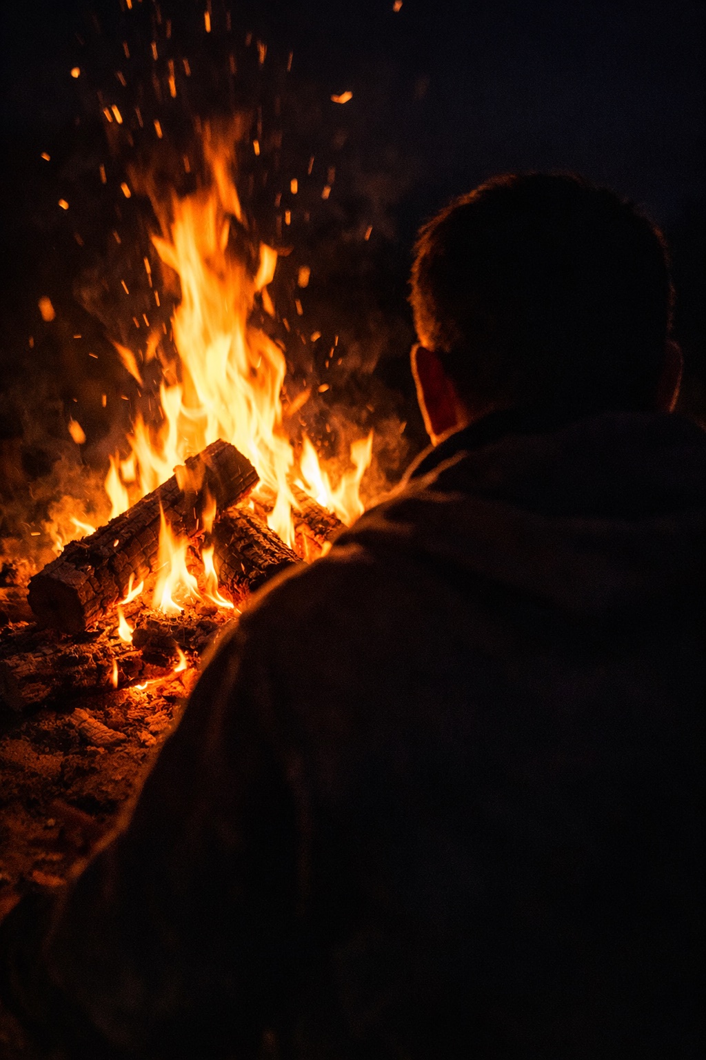 Man reading by a campfire, symbolizing prophetic truth.